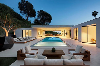 Inspiration for a huge contemporary backyard concrete and rectangular infinity pool remodel in Los Angeles