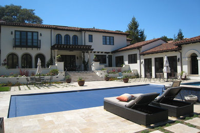 Example of a large tuscan backyard rectangular and stamped concrete lap hot tub design in San Francisco