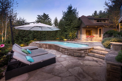 Example of a mid-sized classic backyard stone and kidney-shaped pool house design in Toronto