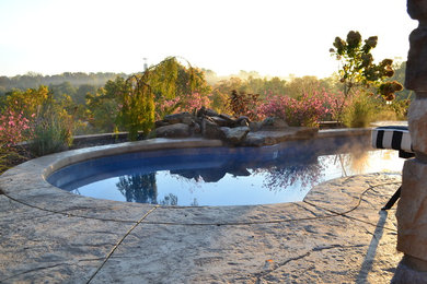 Foto de piscina rústica a medida en patio trasero con suelo de hormigón estampado