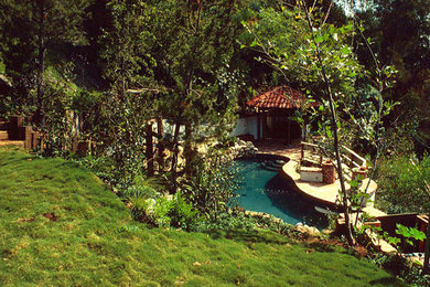 Modelo de casa de la piscina y piscina natural clásica grande a medida en patio trasero con adoquines de piedra natural
