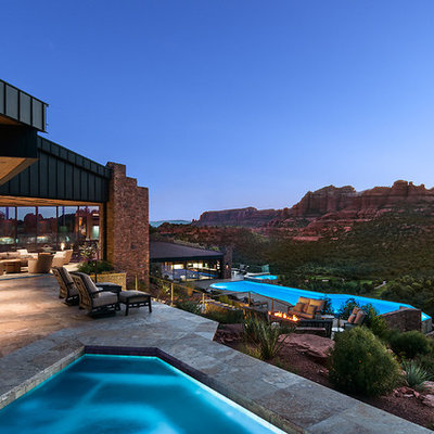 Inspiration for a huge southwestern backyard tile and custom-shaped infinity pool house remodel in Other