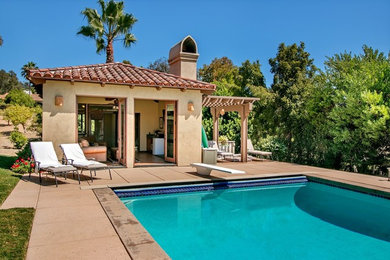 Foto de casa de la piscina y piscina alargada mediterránea grande rectangular en patio trasero con losas de hormigón