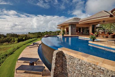 Ejemplo de piscina con fuente infinita exótica extra grande a medida en patio trasero con adoquines de piedra natural