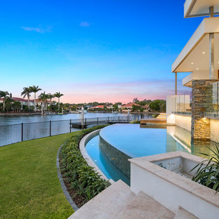 Design ideas for a contemporary backyard infinity pool in Gold Coast - Tweed with a water feature.