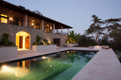 This is an example of a large traditional back rectangular lengths swimming pool in Santa Barbara with natural stone paving.