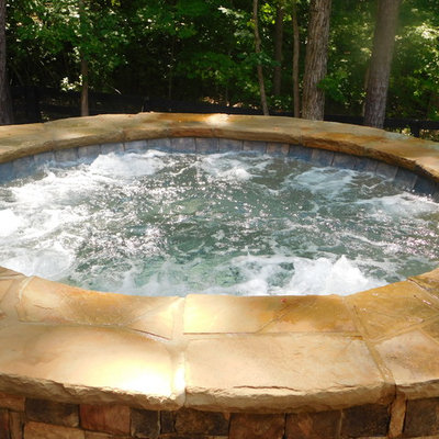 Example of a mid-sized mountain style backyard brick and custom-shaped natural hot tub design in Atlanta