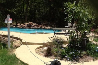 Ejemplo de piscina con fuente tradicional de tamaño medio a medida en patio trasero con losas de hormigón