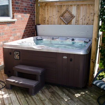 Hot tub - mid-sized traditional backyard custom-shaped aboveground hot tub idea in Other with decking