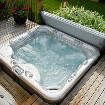 Hot tub - mid-sized traditional backyard custom-shaped aboveground hot tub idea in Other with decking