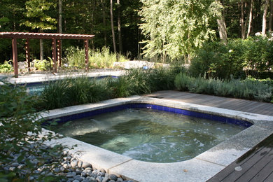 Foto de piscinas y jacuzzis alargados grandes rectangulares en patio trasero con adoquines de piedra natural
