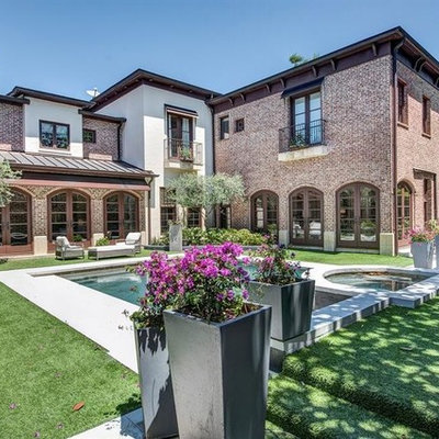 Large tuscan backyard concrete and rectangular lap hot tub photo in Houston