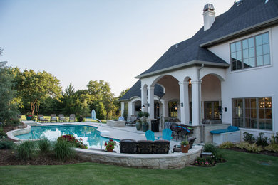 Стильный дизайн: большой бассейн в форме фасоли на заднем дворе в стиле неоклассика (современная классика) с джакузи и покрытием из декоративного бетона - последний тренд
