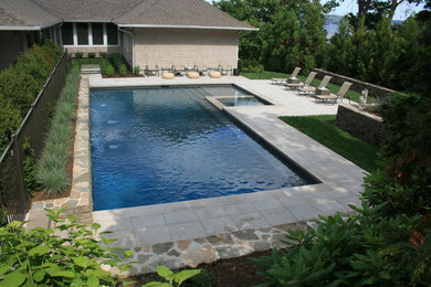Modelo de piscinas y jacuzzis alargados minimalistas de tamaño medio en forma de L en patio trasero con adoquines de hormigón