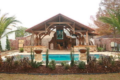 Diseño de piscina alargada tradicional grande rectangular en patio trasero con adoquines de hormigón