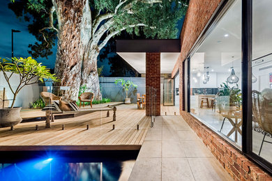 Cette image montre une piscine design avec une terrasse en bois.