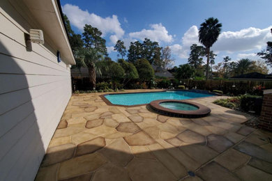 Imagen de piscinas y jacuzzis clásicos grandes a medida en patio trasero con adoquines de hormigón
