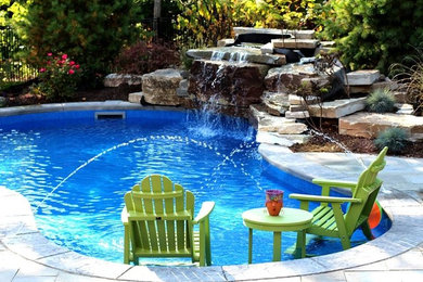 Foto de piscina con fuente de tamaño medio a medida en patio trasero con suelo de hormigón estampado