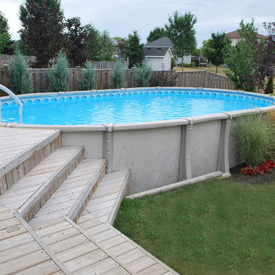 Inspiration for a mid-sized timeless backyard round aboveground pool remodel in Toronto with decking