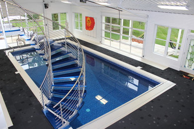 Imagen de casa de la piscina y piscina moderna grande rectangular en patio trasero con suelo de baldosas