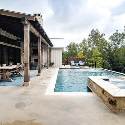 Huge farmhouse backyard concrete and rectangular hot tub photo in Austin