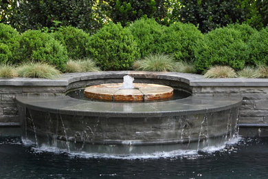 This is an example of a small contemporary back rectangular natural swimming pool in Atlanta with a water feature.