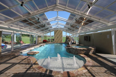 Idee per una grande piscina coperta monocorsia chic rettangolare con una vasca idromassaggio e pavimentazioni in cemento