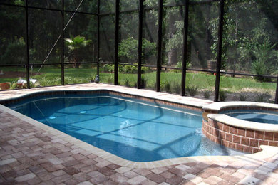 Imagen de piscinas y jacuzzis alargados tradicionales de tamaño medio rectangulares en patio trasero con adoquines de ladrillo