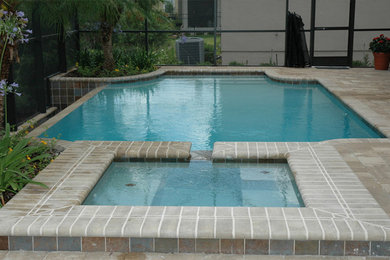 Ejemplo de piscina natural de tamaño medio a medida en patio trasero con adoquines de hormigón