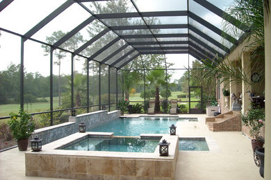 Idee per una grande piscina coperta rettangolare con una dépendance a bordo piscina e lastre di cemento