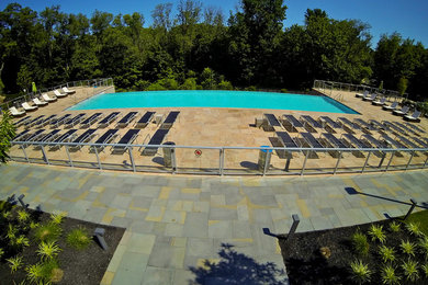 Pool fountain - huge contemporary backyard stone and rectangular infinity pool fountain idea in Philadelphia