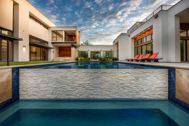 На фото: большой прямоугольный бассейн в стиле модернизм с покрытием из бетонных плит с