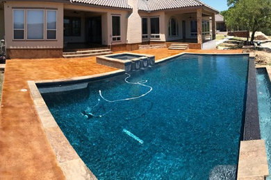 Foto de piscinas y jacuzzis infinitos mediterráneos extra grandes rectangulares en patio trasero con entablado