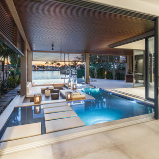 Geräumiger Moderner Infinity-Pool hinter dem Haus in individueller Form mit Dielen in Miami