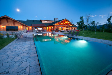 Example of a large trendy backyard stone and rectangular pool design in Boise