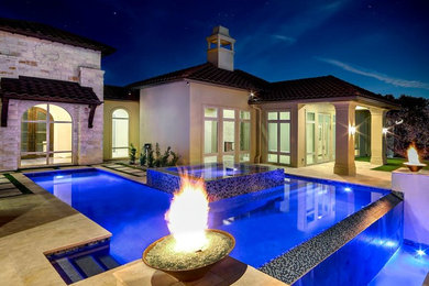 Imagen de piscinas y jacuzzis infinitos minimalistas grandes rectangulares en patio trasero con suelo de hormigón estampado