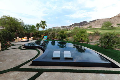 Mid-sized minimalist backyard stone and custom-shaped infinity hot tub photo in Las Vegas