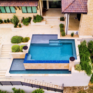 Ispirazione per un'ampia piscina a sfioro infinito moderna rettangolare dietro casa con lastre di cemento