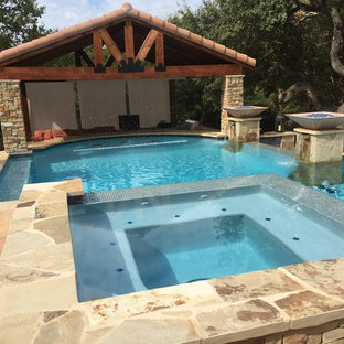 Immagine di una grande piscina a sfioro infinito rustica personalizzata dietro casa con una vasca idromassaggio e pedane