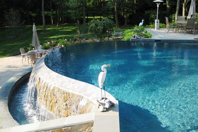 Mid-sized transitional backyard custom-shaped infinity pool fountain photo in Baltimore