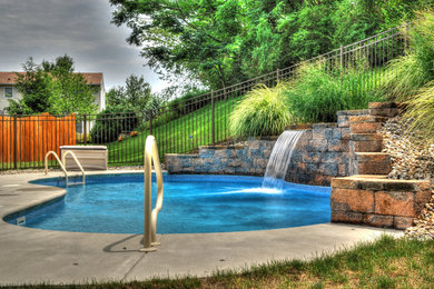 Example of a small tuscan backyard concrete and kidney-shaped lap pool design in Other