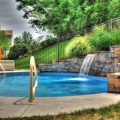 Example of a small tuscan backyard concrete and kidney-shaped lap pool design in Other