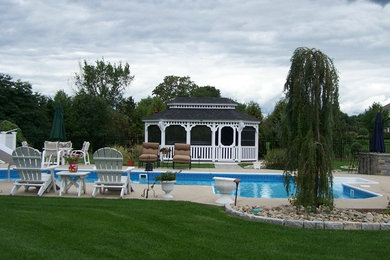 Photo of a back custom shaped swimming pool in Bridgeport with concrete slabs.
