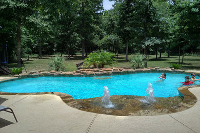 Inspiration for a mid-sized tropical backyard custom-shaped natural pool fountain remodel in Houston with decking