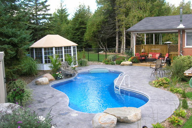 Modelo de piscina con fuente natural tradicional pequeña a medida en patio trasero con suelo de hormigón estampado