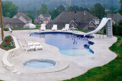 Inspiration for a large traditional back custom shaped natural swimming pool in New York with concrete slabs and a water slide.