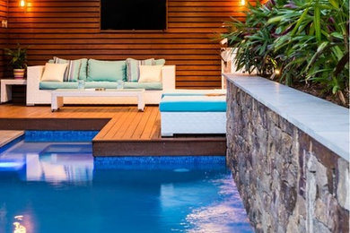 Modelo de piscina alargada exótica de tamaño medio rectangular en patio trasero con entablado