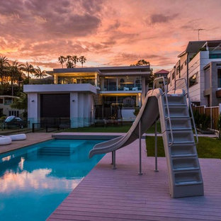 Idee per una piscina monocorsia design rettangolare di medie dimensioni e dietro casa con un acquascivolo e pedane