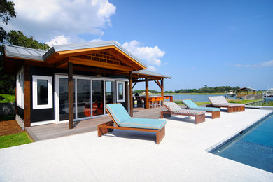 Imagen de casa de la piscina y piscina ecléctica de tamaño medio rectangular en patio trasero con suelo de hormigón estampado