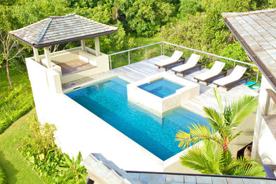 This is an example of a contemporary swimming pool in Hawaii with decking.